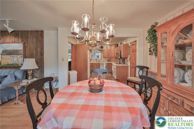 4379 Meadow Ln, South Whitehall Twp, PA 18104 - dining space with a chandelier, light wood-type flooring, and wooden walls