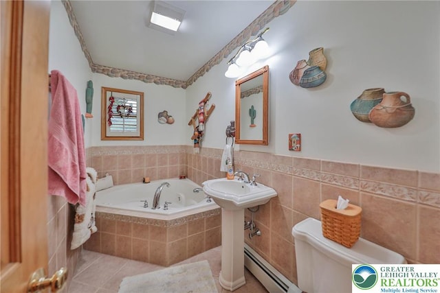 4379 Meadow Ln, South Whitehall Twp, PA 18104 - bathroom featuring a tub with jets, tile patterned floors, toilet, tile walls, and a wainscoted wall