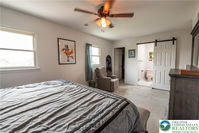 1411 Howard Ln, Palmer Twp, PA 18045 - bedroom featuring a barn door, light colored carpet, ensuite bathroom, a spacious closet, and ceiling fan