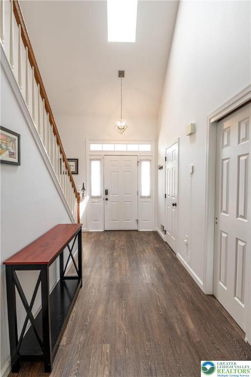 1411 Howard Ln, Palmer Twp, PA 18045 - foyer entrance with dark wood finished floors, stairway, high vaulted ceiling, and baseboards