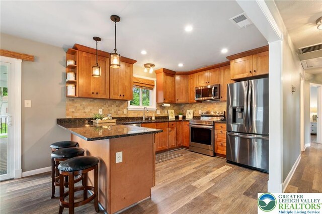 201 S 15th St, Emmaus Borough, PA 18049 - kitchen featuring stainless steel appliances, a peninsula, light wood-type flooring, baseboards, and decorative backsplash