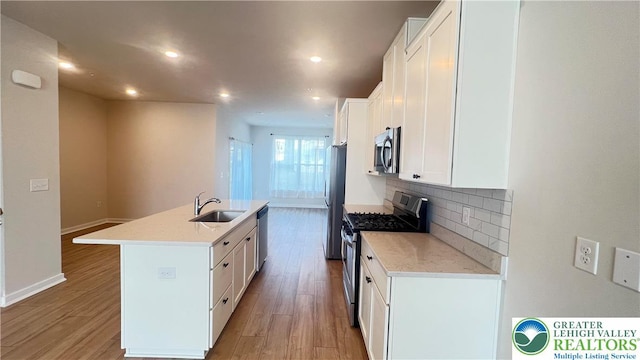 4904 Brookside Ct, Upper Saucon Twp, PA 18036 - kitchen featuring appliances with stainless steel finishes, a sink, a kitchen island with sink, white cabinets, and decorative backsplash