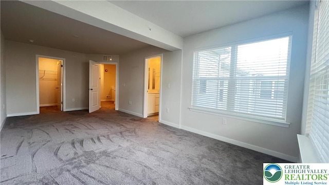 4904 Brookside Ct, Upper Saucon Twp, PA 18036 - unfurnished bedroom with carpet, multiple windows, a walk in closet, and baseboards