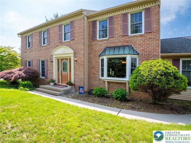 5054 Rainbow Ct, Lower Macungie Twp, PA 18106 - georgian-style home with a front yard, brick siding, and a shingled roof
