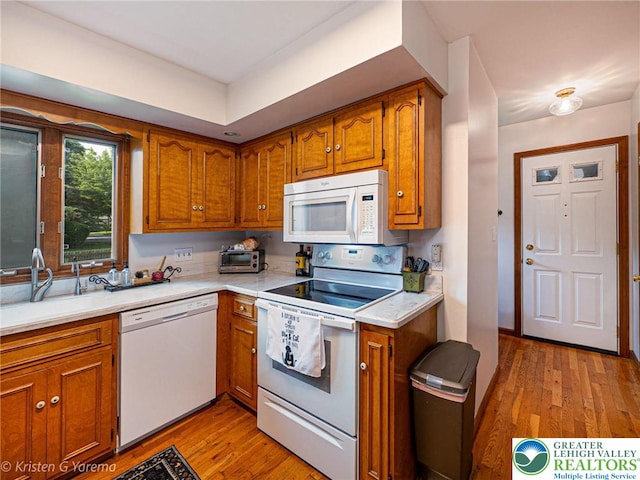 5054 Rainbow Ct, Lower Macungie Twp, PA 18106 - kitchen featuring white appliances, brown cabinets, light countertops, and light wood finished floors