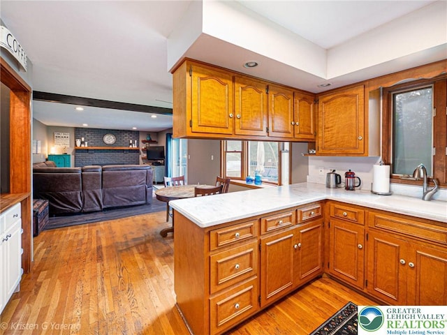 5054 Rainbow Ct, Lower Macungie Twp, PA 18106 - kitchen featuring a sink, brown cabinetry, light wood-style floors, light countertops, and a peninsula