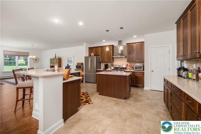 222 Danbury Dr, Bushkill Twp, PA 18064 - kitchen featuring appliances with stainless steel finishes, a kitchen island, wall chimney range hood, backsplash, and light countertops
