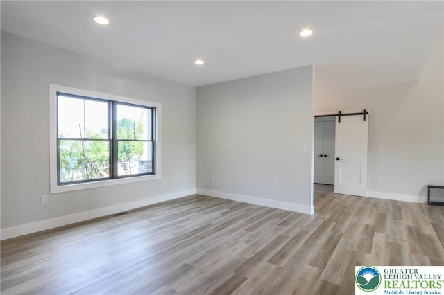 448 Long Lane Rd, Lehigh Twp, PA 18088 - unfurnished room with a barn door, light wood-style flooring, baseboards, and recessed lighting
