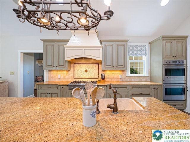 5355 Saucon Ridge Rd, Upper Saucon Twp, PA 18036 - kitchen featuring custom exhaust hood, stainless steel appliances, a chandelier, tasteful backsplash, and a sink