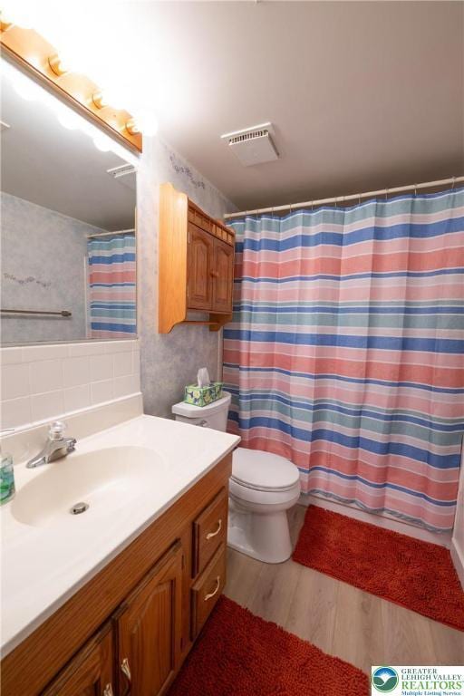 2765 Rolling Green Pl, Lower Macungie Twp, PA 18062 - full bathroom with wood finished floors, vanity, toilet, a shower with shower curtain, and wallpapered walls