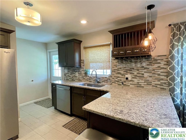 938 N Broad St, Allentown City, PA 18104 - kitchen featuring stainless steel appliances, a sink, dark brown cabinetry, tasteful backsplash, and light stone countertops
