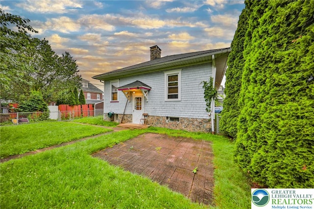 30 S 16th St, Wilson Boro, PA 18042 - back of property at dusk with a chimney and a patio
