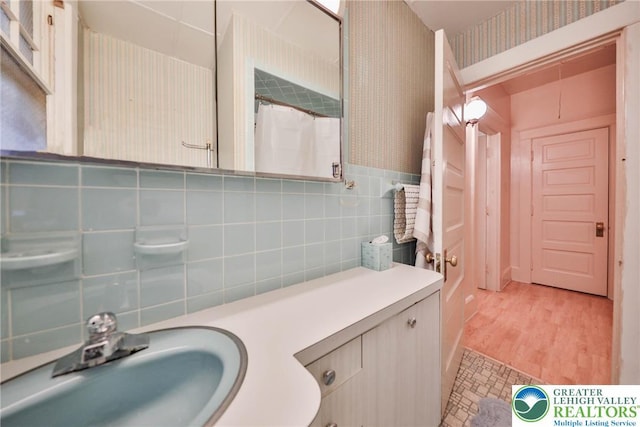 30 S 16th St, Wilson Boro, PA 18042 - bathroom with vanity, wallpapered walls, tile walls, wood finished floors, and backsplash