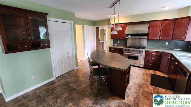 391 W Mayfield Cir, Lower Nazareth Twp, PA 18020 - kitchen featuring stainless steel stove, wall chimney range hood, baseboards, stone finish floors, and a breakfast bar