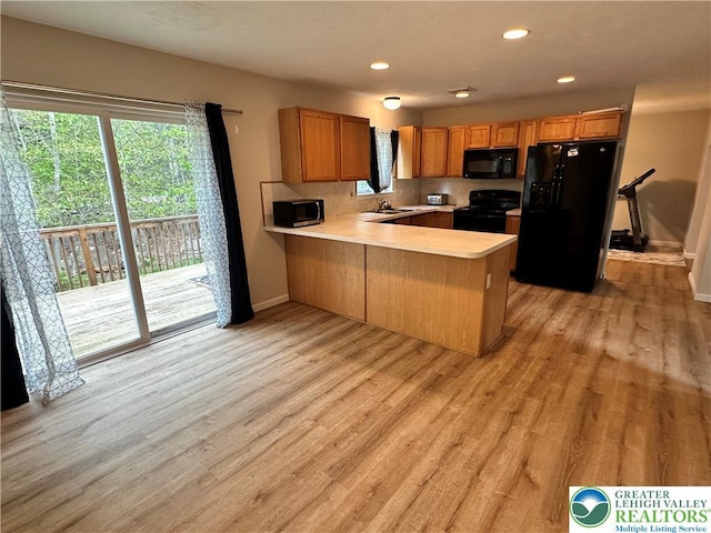 7190 Rimrock Dr, Coolbaugh Twp, PA 18466 - kitchen featuring black appliances, light countertops, a peninsula, light wood-style flooring, and baseboards