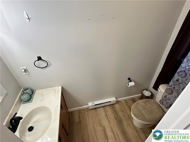 7190 Rimrock Dr, Coolbaugh Twp, PA 18466 - bathroom featuring baseboard heating, wood finished floors, toilet, and vanity