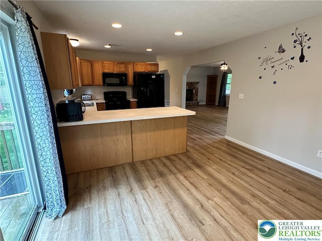 7190 Rimrock Dr, Coolbaugh Twp, PA 18466 - kitchen featuring black appliances, arched walkways, a peninsula, light countertops, and baseboards