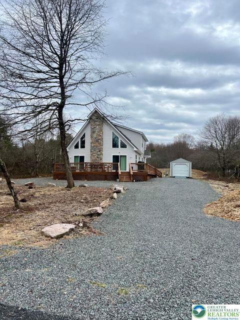22 Petrarch Trl, Penn Forest Twp, PA 18210 - view of side of home featuring an outbuilding, a deck, driveway, and stone siding