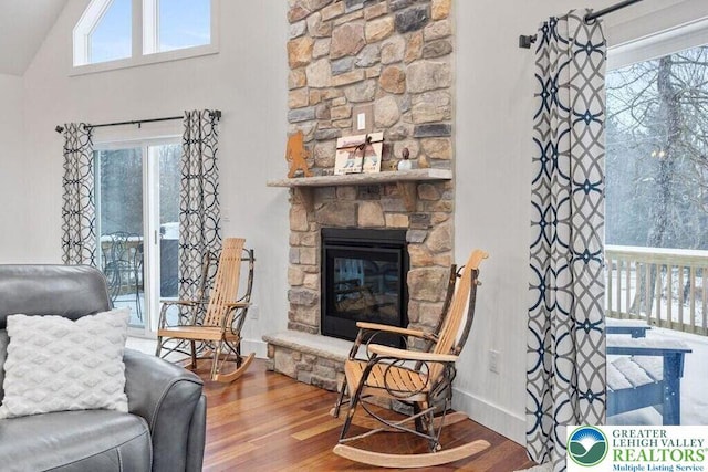 22 Petrarch Trl, Penn Forest Twp, PA 18210 - living area featuring wood finished floors, plenty of natural light, a stone fireplace, vaulted ceiling, and baseboards