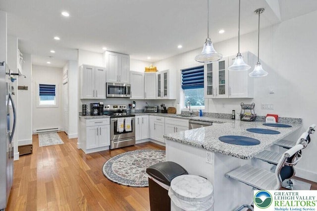 22 Petrarch Trl, Penn Forest Twp, PA 18210 - kitchen with appliances with stainless steel finishes, a baseboard heating unit, a kitchen breakfast bar, a sink, and a peninsula