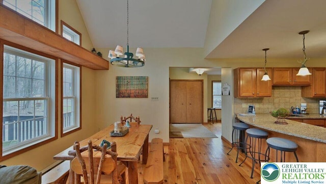 97 Lucretius Trl, Penn Forest Twp, PA 18210 - dining area featuring light wood-type flooring, a chandelier, high vaulted ceiling, and baseboards