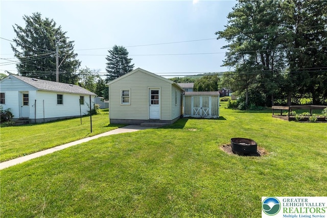 2104 Schwab Ave, Lower Saucon Twp, PA 18015 - view of green lawn featuring a fire pit, an outdoor structure, and entry steps