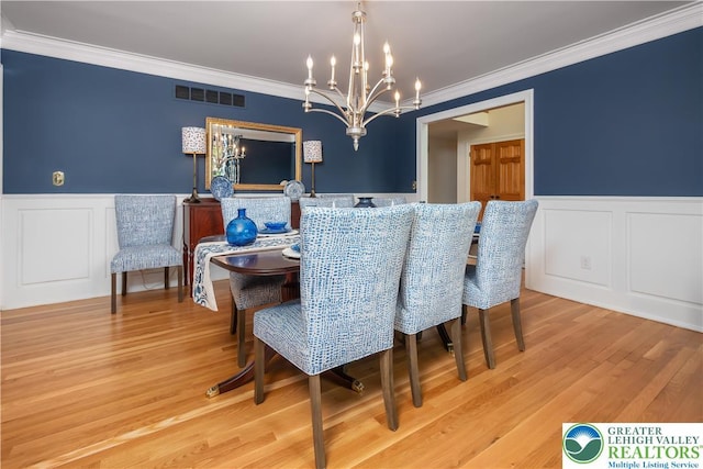 1560 Surrey Rd, Lower Saucon Twp, PA 18015 - dining space with a chandelier, wainscoting, ornamental molding, light wood finished floors, and a decorative wall