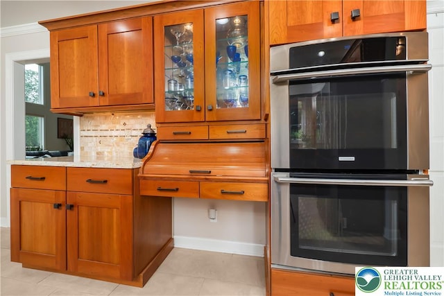 1560 Surrey Rd, Lower Saucon Twp, PA 18015 - kitchen featuring stainless steel double oven, brown cabinets, backsplash, baseboards, and glass insert cabinets