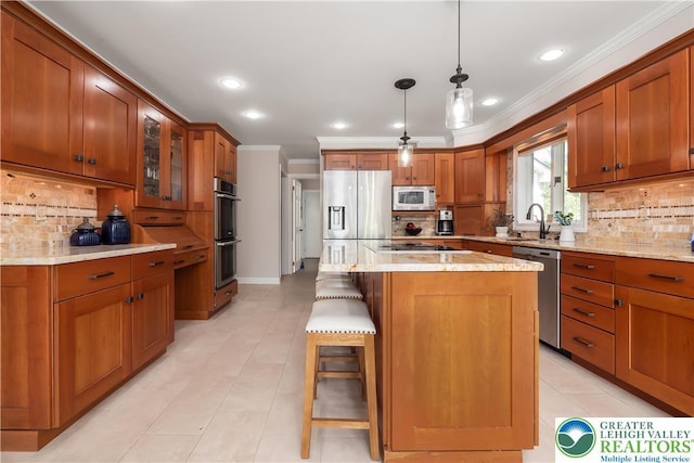 1560 Surrey Rd, Lower Saucon Twp, PA 18015 - kitchen featuring appliances with stainless steel finishes, ornamental molding, brown cabinets, backsplash, and a kitchen bar