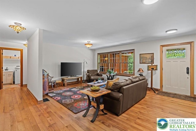 127 Timber Lake Dr, Barrett Twp, PA 18325 - living area with washer / clothes dryer and light wood finished floors