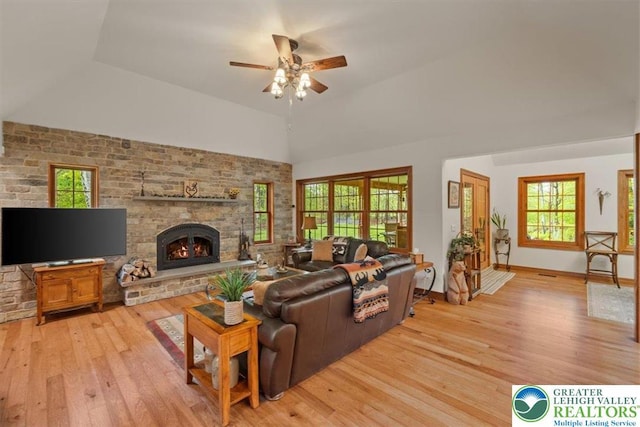 127 Timber Lake Dr, Barrett Twp, PA 18325 - living room with light wood-style flooring, vaulted ceiling, a ceiling fan, a stone fireplace, and plenty of natural light