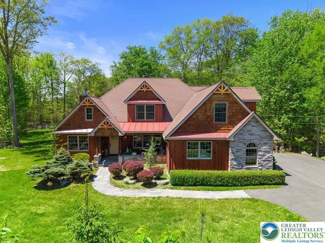 127 Timber Lake Dr, Barrett Twp, PA 18325 - craftsman inspired home featuring a front yard, covered porch, a standing seam roof, and board and batten siding