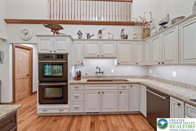 127 Timber Lake Dr, Barrett Twp, PA 18325 - kitchen with stainless steel appliances, a sink, tasteful backsplash, and light wood-type flooring