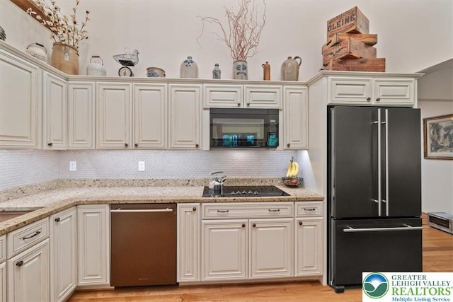 127 Timber Lake Dr, Barrett Twp, PA 18325 - kitchen featuring black appliances, backsplash, light wood-style flooring, and light stone countertops