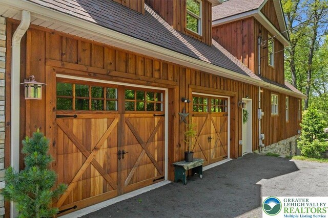 127 Timber Lake Dr, Barrett Twp, PA 18325 - view of exterior entry with roof with shingles and board and batten siding