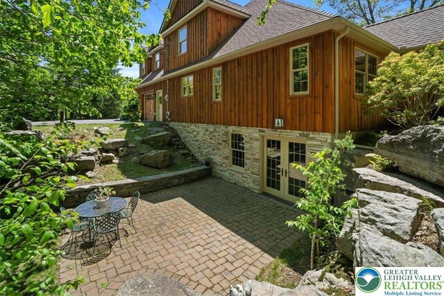 127 Timber Lake Dr, Barrett Twp, PA 18325 - view of home's exterior featuring a shingled roof, a patio, french doors, and board and batten siding