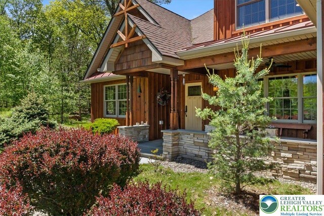 127 Timber Lake Dr, Barrett Twp, PA 18325 - view of front of property with board and batten siding, a shingled roof, and covered porch