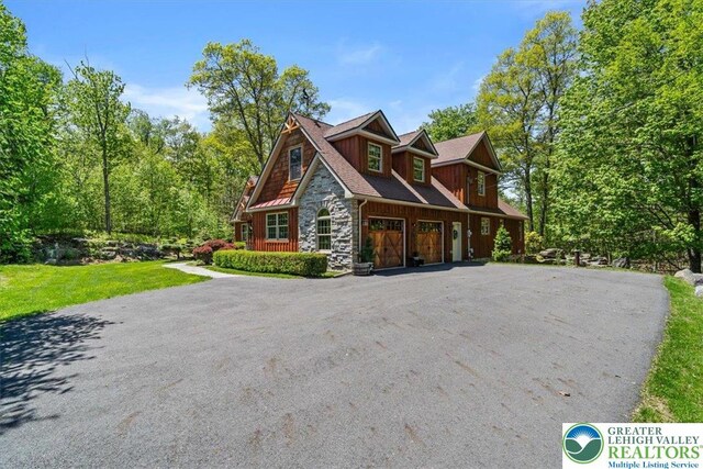 127 Timber Lake Dr, Barrett Twp, PA 18325 - view of front of house featuring stone siding, an attached garage, asphalt driveway, and a front lawn