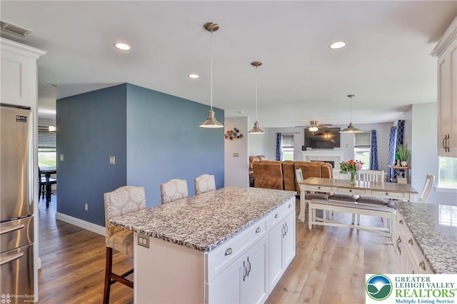 217 E Dell Rd, Moore Twp, PA 18014 - kitchen featuring freestanding refrigerator, ceiling fan, a kitchen breakfast bar, wood finished floors, and hanging light fixtures