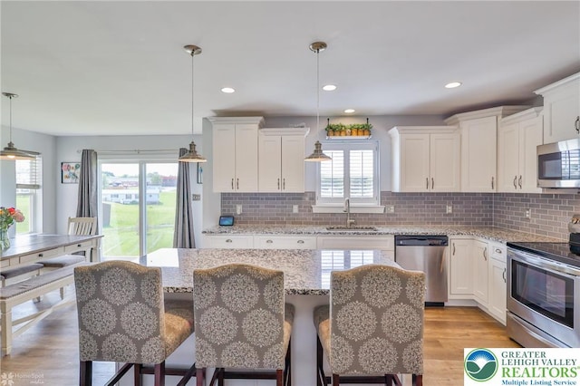 217 E Dell Rd, Moore Twp, PA 18014 - kitchen with appliances with stainless steel finishes, a sink, white cabinetry, decorative backsplash, and light wood finished floors