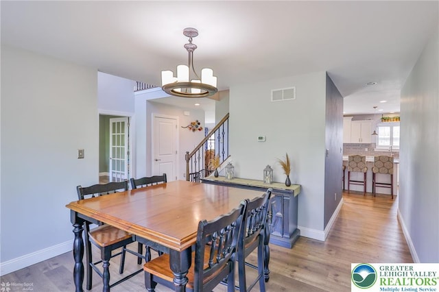 217 E Dell Rd, Moore Twp, PA 18014 - dining room featuring a chandelier, light wood-style floors, stairs, and baseboards