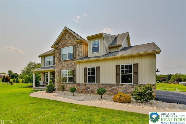 217 E Dell Rd, Moore Twp, PA 18014 - view of front facade with stone siding, a front lawn, a shingled roof, and board and batten siding