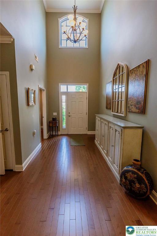 1069 Resolution Dr, Bethlehem City, PA 18017 - foyer featuring dark wood finished floors, healthy amount of natural light, a chandelier, crown molding, and a high ceiling
