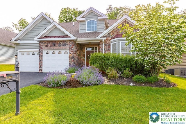 1069 Resolution Dr, Bethlehem City, PA 18017 - view of front facade featuring stone siding, asphalt driveway, a front yard, an attached garage, and roof with shingles