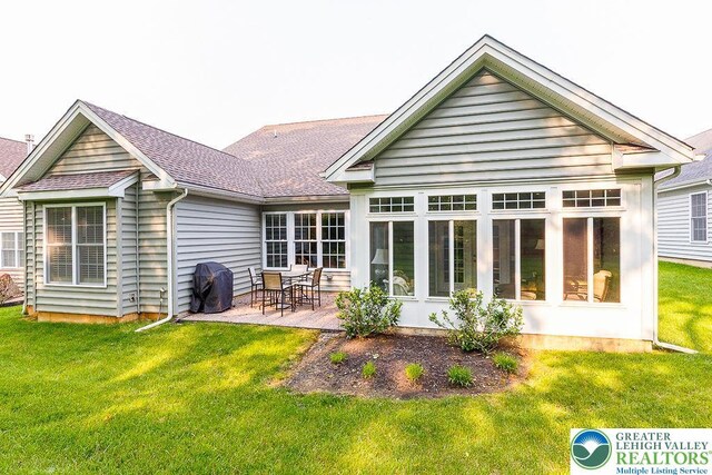 1069 Resolution Dr, Bethlehem City, PA 18017 - back of property featuring a patio, a yard, roof with shingles, and a sunroom