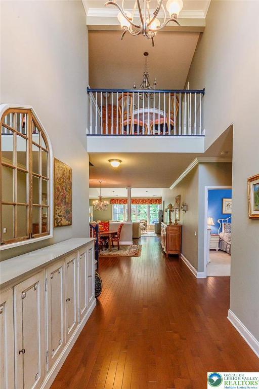 1069 Resolution Dr, Bethlehem City, PA 18017 - hallway with a chandelier, a towering ceiling, wood-type flooring, and ornamental molding