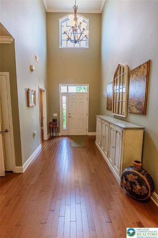 1069 Resolution Dr, Bethlehem City, PA 18017 - entrance foyer featuring dark wood-style flooring, plenty of natural light, ornamental molding, a towering ceiling, and a chandelier