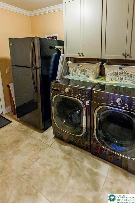 1069 Resolution Dr, Bethlehem City, PA 18017 - laundry room with cabinet space, crown molding, independent washer and dryer, and light tile patterned flooring