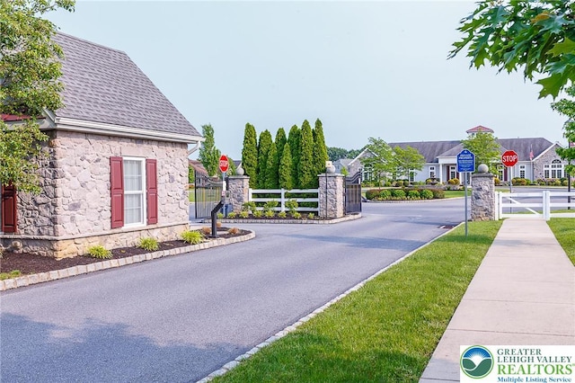 1069 Resolution Dr, Bethlehem City, PA 18017 - view of asphalt street featuring traffic signs, curbs, a gated entry, and sidewalks