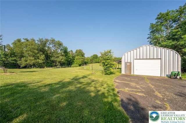 68 Knoll Cir, Boyertown, PA 19512 - view of green lawn with an outbuilding, a detached garage, and asphalt driveway